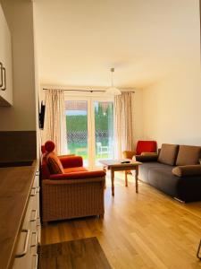 un soggiorno con un divano e un tavolo di Hubertus Terrace&Garden Apartment a Garmisch-Partenkirchen Altre 2 foto