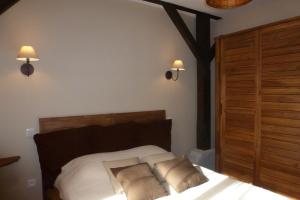 ein Schlafzimmer mit einem Bett mit zwei Kissen darauf in der Unterkunft Gite en forêt landaise avec jacuzzi d'intérieur in Pissos