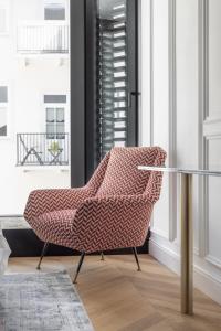 una silla en una habitación con mesa de cristal en AS Boutique Hotel, superior, en Liubliana