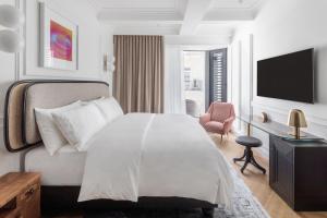 um quarto branco com uma cama e uma televisão em AS Boutique Hotel, superior em Ljubljana