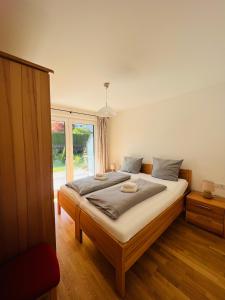una camera da letto con un letto e una grande finestra di Hubertus Terrace&Garden Apartment a Garmisch-Partenkirchen