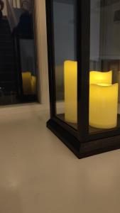 un espejo con dos velas amarillas delante de una ventana en Chapel Nazareth, en Penrhyndeudreath