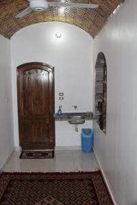 a bathroom with a sink and a wooden door at Nile View (2) Guest House in Aswan