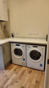 a kitchen with two washing machines and a counter at Chapel Nazareth in Penrhyndeudreath