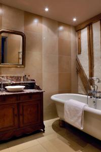 y baño con bañera, lavabo y espejo. en Golf de Rebetz- Domaine de Rebetz, en Chaumont-en-Vexin