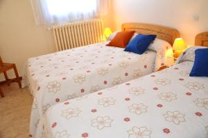 - une chambre avec 2 lits et des draps fleuris dans l'établissement Résidence Torremagne 7, à Font-Romeu-Odeillo-Via