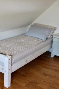 a bed with a white bed frame in a room at Haus Strandleben in Hohwacht