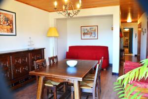 a dining room with a table and a red couch at Résidence Torremagne 4 in Font-Romeu-Odeillo-Via