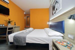 ローマにあるLHG Comfy Roomsの大きなベッドとテーブルが備わるホテルルームです。