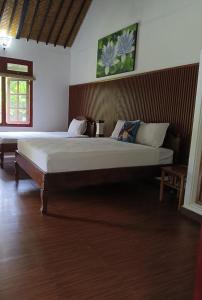 1 dormitorio con 1 cama grande en una habitación en Taman Lituhayu Cottages, en Ubud