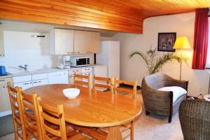 a kitchen and dining room with a wooden table and chairs at Location vacances Pyrénées, grand T4 dans petite résidence, vue panoramique, centre station in Font-Romeu-Odeillo-Via