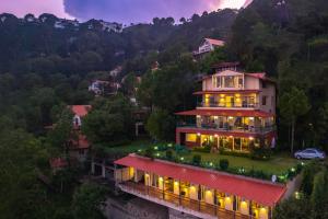 a house on a hill with lights on it at StayVista at Ludlow House Luxury 4BHK Valley View villa in Kasauli with Sauna room in Kasauli
