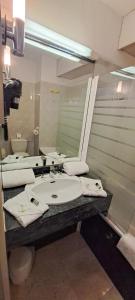 ein Badezimmer mit einem Waschbecken und einem großen Spiegel in der Unterkunft Appart'hôtel Le Trianon in Arcachon