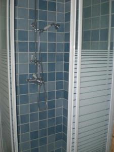 y baño con ducha de azulejos azules. en Villa Azur, en Lorgues