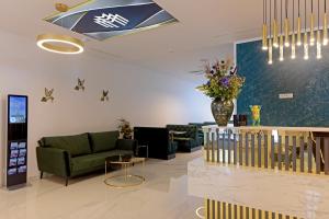 a lobby with a couch and a vase of flowers at M-Pire Hotel Berlin in Berlin