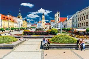 a group of people sitting on a bench in a city at Apartmán CENTRAL, near the center, self check in 24 h, free parking in Banská Bystrica