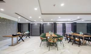 un restaurante con mesas de madera y sillas verdes en Treebo Trend Royal Comfort, en Nueva Delhi