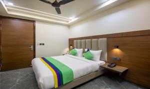 1 dormitorio con 1 cama grande y puerta de madera en Treebo Trend Royal Comfort, en Nueva Delhi