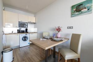 a small kitchen with a table and a dining room at OVELIA Strasbourg - Les Jardins des Deux Rives in Strasbourg