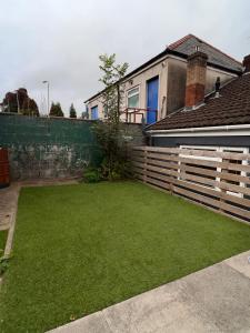 a backyard with a fence and green grass at Forge Cottage in Mountain Ash