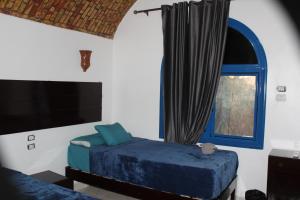 1 dormitorio con 2 camas y ventana en Nile View (2) Guest House en Asuán