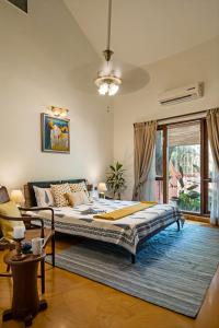 a bedroom with a large bed and a couch at LohonoStays Villa Lani in Alibag +19 photos