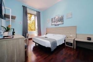 Schlafzimmer mit einem Bett, einem Schreibtisch und einem Waschbecken in der Unterkunft LHG Comfy Rooms in Rom
