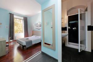 Schlafzimmer mit einem Bett, einem Waschbecken und einem Spiegel in der Unterkunft LHG Comfy Rooms in Rom