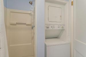 a small white kitchen with a washer and dryer at Painted Porch Cottage in Lakeside +21 photos