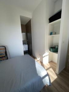 een witte slaapkamer met een bed in een kamer bij T1 Cocon proche du stade app 102 in Saint-Étienne