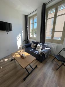 een woonkamer met een bank en een salontafel bij T1 Cocon proche du stade app 102 in Saint-Étienne
