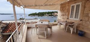 balcón con mesa, sillas y vistas al agua en Apartments Jurić - 2 A lovely room for 2 en Hvar