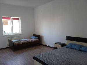 um quarto com 2 camas e uma janela em Частый дом em Kapchagay