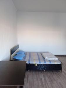 uma cama com almofadas azuis num quarto em Частый дом em Kapchagay