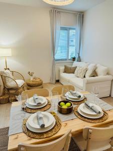 - un salon doté d'une table avec des assiettes et des verres à vin dans l'établissement Cozy and Unique apartment near train station, à Bratislava