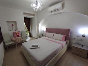 um quarto com uma cama grande e uma cadeira em Affittacamere Silvagni em Caserta