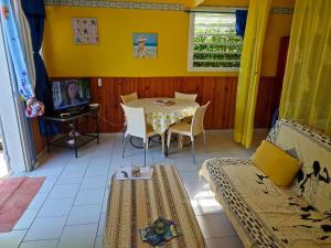 Gîtes TAINACO في فيو-هابيتانتيس: غرفة مع طاولة وسرير وتلفزيون