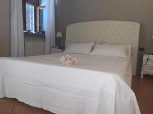 a white bed with flowers on top of it at Maison Diletta in Castelletto sopra Ticino