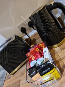 a black toaster on a table with a bag of candy at Homestay by BIC Wellfield 2 in Dewsbury