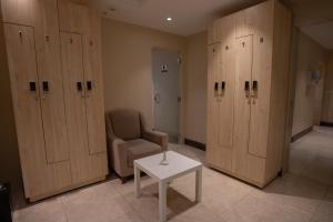 a room with wooden lockers and a chair and a table at Rosemond Al Hamra in Jeddah