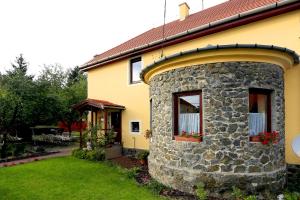 a yellow house with a stone wall at Nemes Apartman in Eger