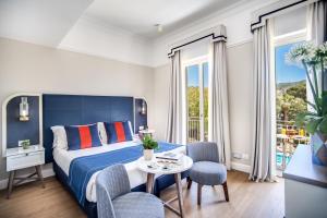 une chambre d'hôtel avec un lit, une table et des chaises dans l'établissement Hotel Mediterraneo, à Sant'Agnello