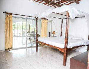 Ένα ή περισσότερα κρεβάτια σε δωμάτιο στο Lux Suites kivulini Cottages Diani Beach
