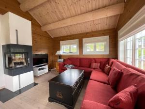 ein Wohnzimmer mit einem roten Sofa und einem TV in der Unterkunft Luxembu - 4 bedroom cabin in Gol