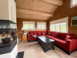 a living room with a red couch in a cabin at Luxembu - 4 bedroom cabin in Gol