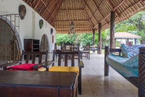 a restaurant with tables and chairs in a building at Lux Suites kivulini Cottages Diani Beach in Diani Beach