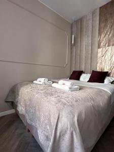 a bedroom with a large bed with towels on it at MB Boutique Apartment Gdansk in Gdańsk