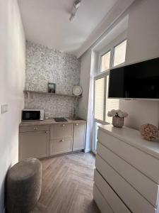 a kitchen with a tv and a chair in a room at MB Boutique Apartment Gdansk in Gdańsk