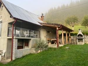 ein Haus mit einer Veranda und einer Terrasse mit einem Grill in der Unterkunft Vikendica Olivia 