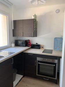 una cucina con armadi neri e piano cottura. di Appartement 40m2 vue sur mer accès direct plage et parking privé a Dinard